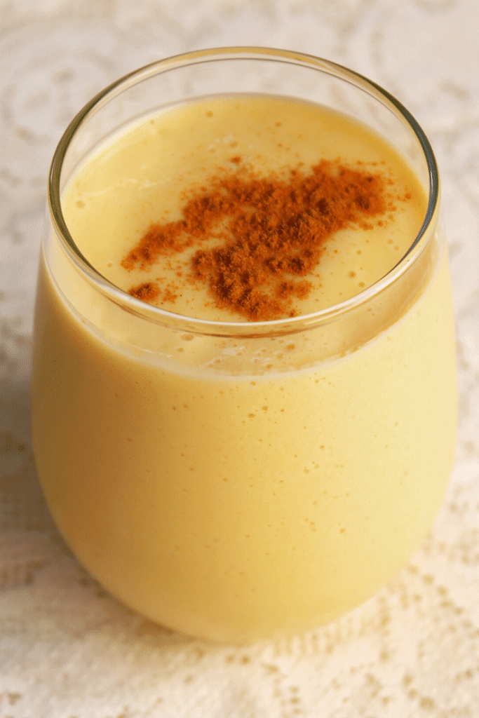 A thick, golden drink garnished with fresh spices on top