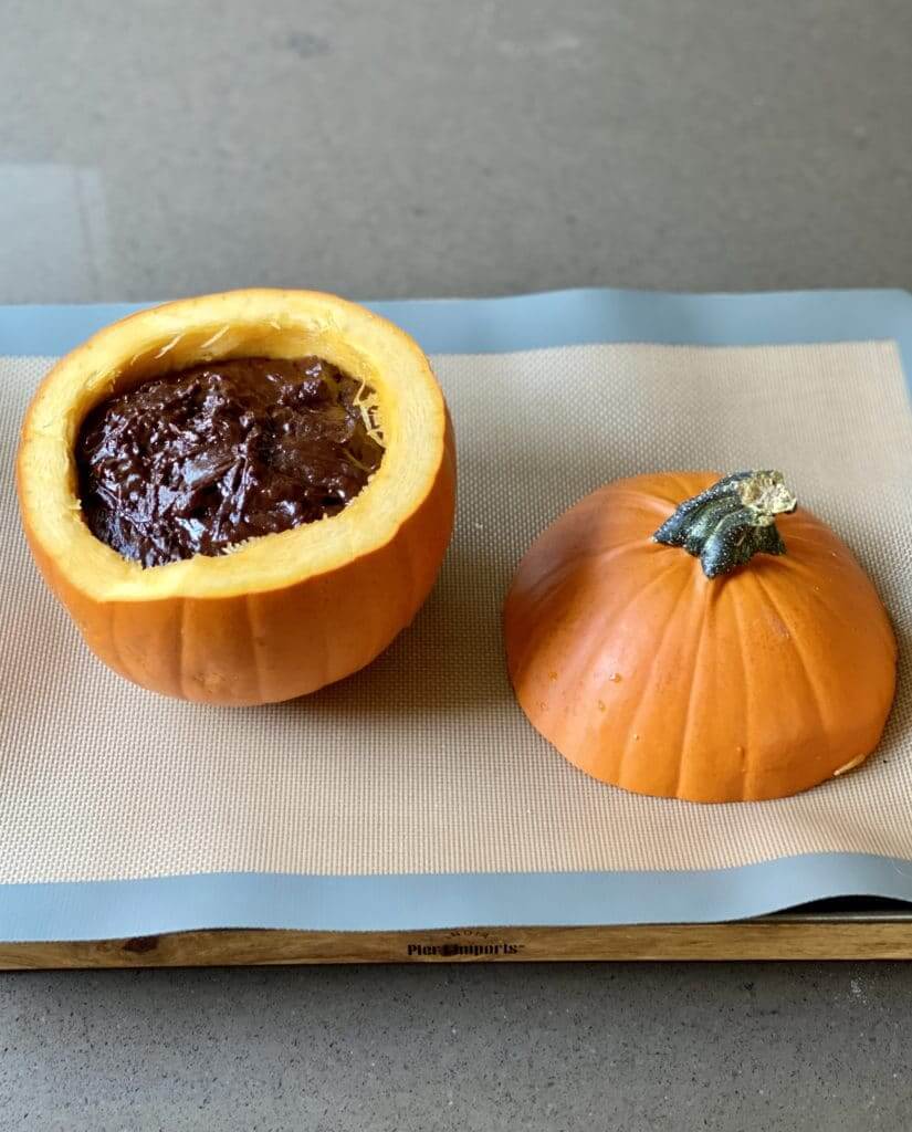 unbaked chocolate cake in the bottom of a pumpkin