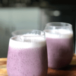 2 purple smoothies in short glasses with spinach and blueberries as garnish