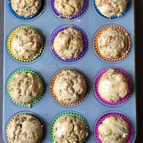 Zucchini muffins in a 12-tin with brightly colored liners