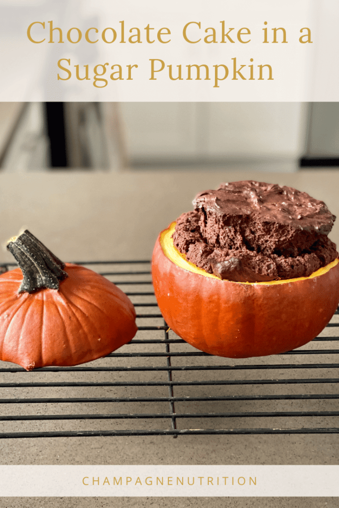 A chocolate cake baked in a pumpkin cooling on a rack
